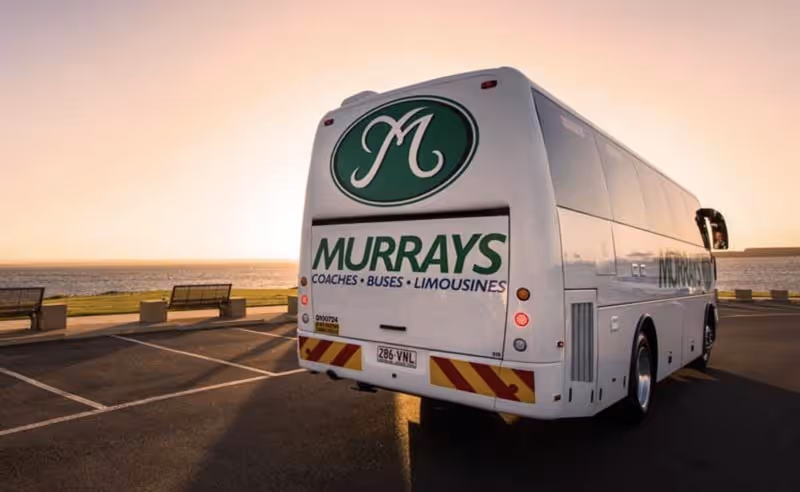 Image of a Murrays Coach on the road at sunset.